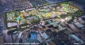 A dazzling nighttime aerial shot of Disneyland, illuminated with vibrant lights highlighting iconic attractions, winding pathways, and the surrounding cityscape—showcasing the park’s magical transformation and immersive Disney-themed details.