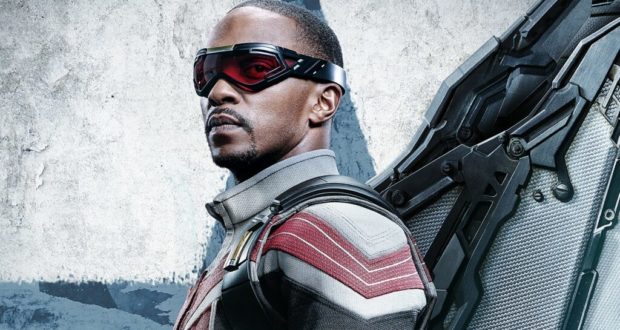 The Falcon wearing his new superhero suit with red goggles and mechanical wings poses in front of a gray backdrop, ready for action as seen in The Falcon and the Winter Soldier.