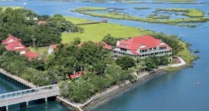 Disney’s Hilton Head Island Resort showcases its welcoming waterfront lodge with a vibrant red roof, nestled among picturesque marshlands, scenic water views, and charming bridges—evoking the laid-back magic and immersive atmosphere fans love about Disney destinations.