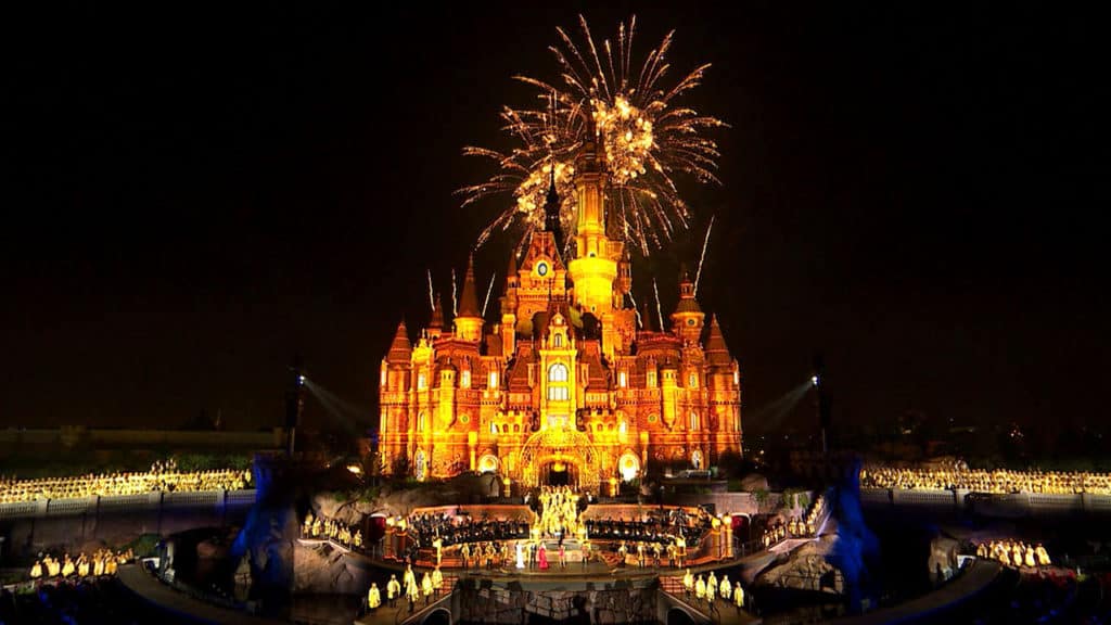 Fireworks burst above the glowing Disney castle, enchanting the crowd during a spectacular nighttime show—one of many unforgettable experiences that Disney Parks guests and Disney+ fans cherish.