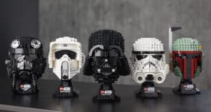 Five LEGO Star Wars helmet models arranged on a table, resembling an immersive display you’d find at a themed attraction or pop-up at Star Wars: Galaxy’s Edge, set against a sleek gray wall—inviting guests to explore and get inspired to create their own galactic adventure.