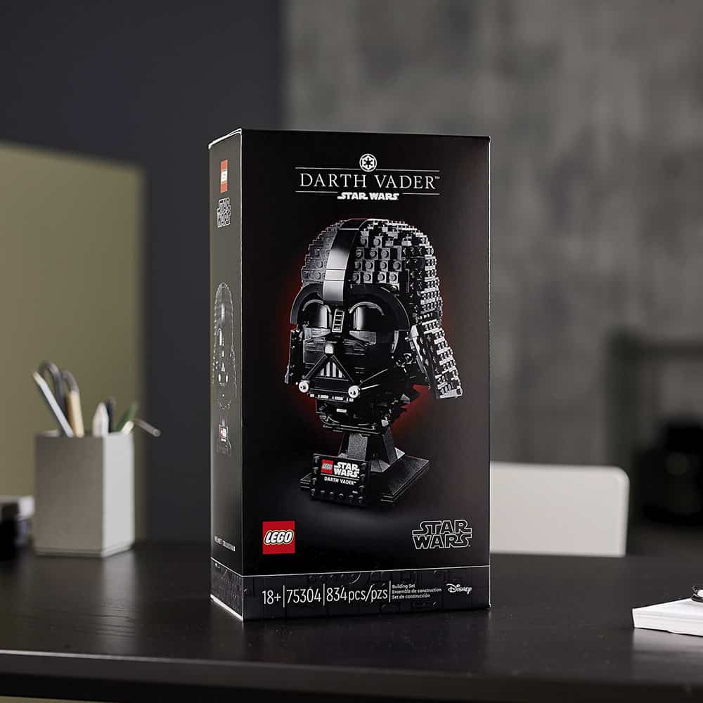 The LEGO Star Wars Darth Vader helmet set box stands out on a themed office desk, surrounded by everyday supplies, just like an exclusive collectible at Galaxy's Edge. An eye-catching piece for any Star Wars enthusiast’s workspace, this display brings the thrill of building your own empire into the daily adventure—no trip to Disney Parks required.