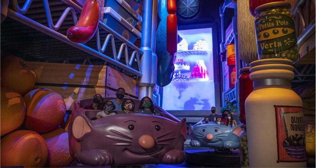 Remy's Ratatouille Adventure at EPCOT whisks guests away in mouse-shaped ride vehicles, racing through a whimsical, larger-than-life kitchen scene brimming with vibrant colors and massive food props.