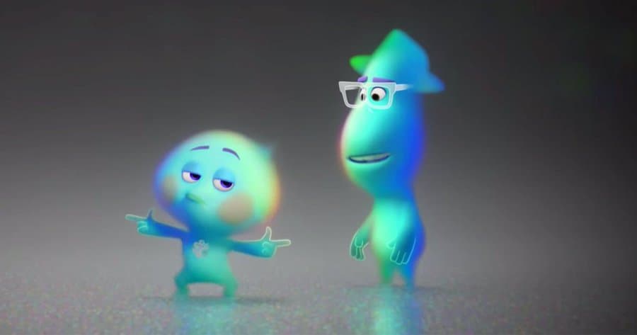 Two vibrant, glowing Pixar-style souls—one with glasses—stand together on a simple backdrop, capturing the lively energy and imaginative fun that fans love in springtime movie releases at popular theme park cinemas.