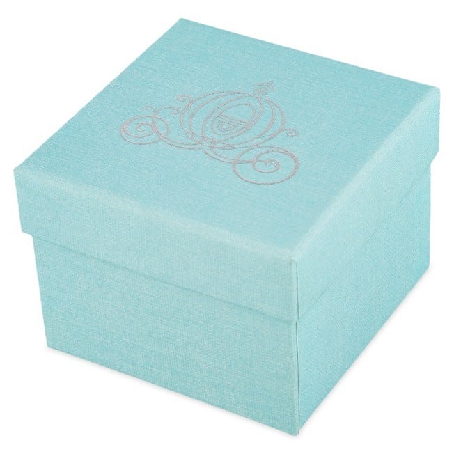 Magical light blue square gift box featuring a shimmering silver pumpkin carriage on the lid, closed and ready to unveil a Disney Fairy Tale Weddings engagement ring—an enchanting keepsake exclusive to shopDisney for fans of Disney parks and magical moments.