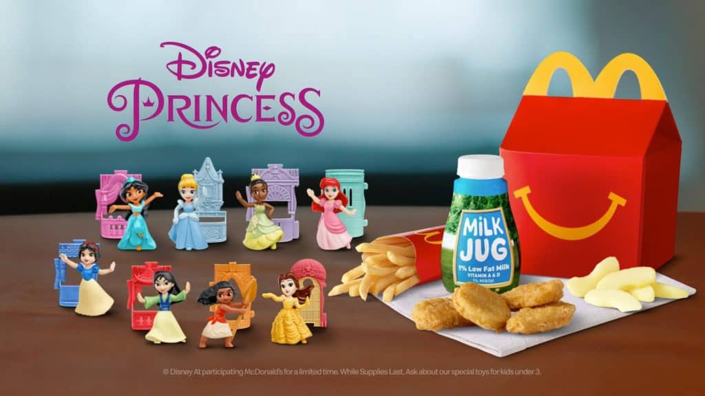 A McDonald’s Happy Meal packed with Disney Princess toys, a milk jug, chicken nuggets, and apple slices rests ready for young fans enjoying a magical moment between rides at Walt Disney World. This kid-friendly meal adds an enchanting Disney twist to classic lunchtime favorites in the heart of the park experience.