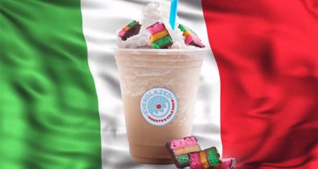 A festive iced drink piled high with rainbow cookies and whipped cream, set against an Italian flag backdrop, brings the flavors of Little Italy to your day at Universal Studios.
