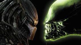 Predator and Alien characters face off in a thrilling themed attraction, with Predator on the left in his signature mask and Alien on the right showing menacing teeth, capturing the excitement of a blockbuster-inspired showdown experience.
