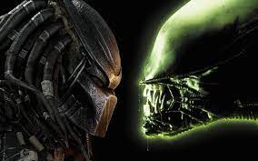 Predator and Alien characters face off in a thrilling themed attraction, with Predator on the left in his signature mask and Alien on the right showing menacing teeth, capturing the excitement of a blockbuster-inspired showdown experience.