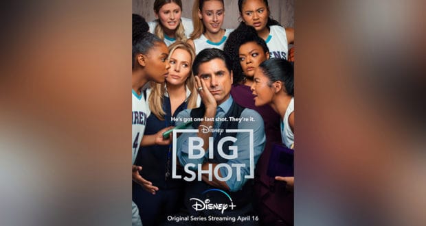 A coach in a suit gathers with his girls' basketball team, all dressed in their team jerseys and focused on him, echoing the vibe of Disney+'s Big Shot as if they're assembled for a post-game huddle at ESPN Wide World of Sports Complex.