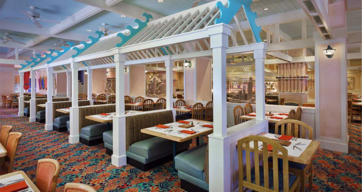 Cape May Café at Disney is ready to welcome guests back with its signature blue booths, wooden chairs, vibrant patterned carpet, and elegant white dividers—all combining for a warm and lively reopening atmosphere that theme park fans will love.