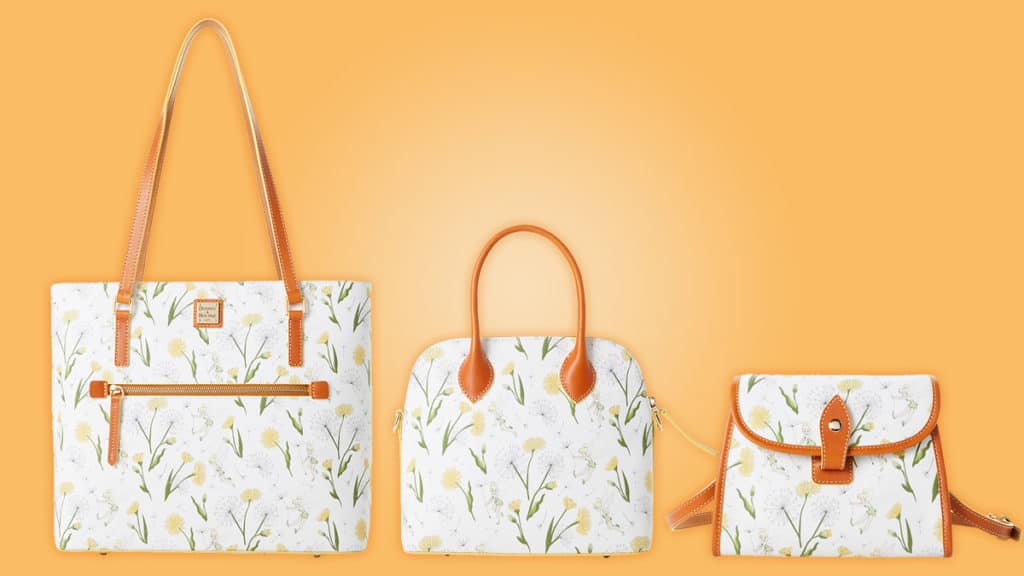 Three white handbags adorned with yellow floral patterns and brown straps from the Disney Collection by Dooney & Bourke are showcased against an orange backdrop, capturing Tinker Bell’s playful magic—perfect for fans looking to bring a bit of Disney Parks enchantment into everyday style.