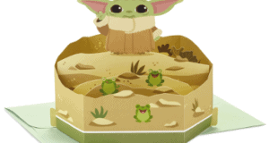 Pop-up 3D card featuring Grogu—known as The Child from Star Wars: The Mandalorian—with his signature big ears, joined by three playful frogs in a sandy Tatooine-inspired scene; an ideal keepsake for Star Wars fans and collectors, reminiscent of the fun found at Galaxy’s Edge.