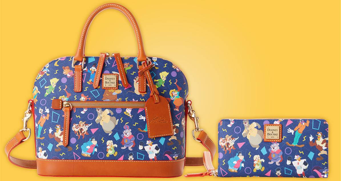 Blue Dooney & Bourke bag and wallet adorned with classic Disney Afternoon characters, complete with brown handles, showcased on a bright yellow backdrop—the ultimate accessories for your next adventure at Disney Springs.