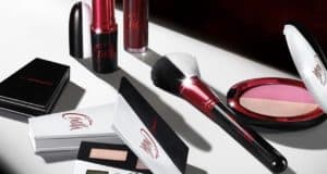 Disney Cruella-themed MAC makeup collection—lipstick, brush, blush, and eyeshadow—arranged on a white surface, inviting Disney Springs visitors to bring home a piece of villainous glamour after their day in the parks.