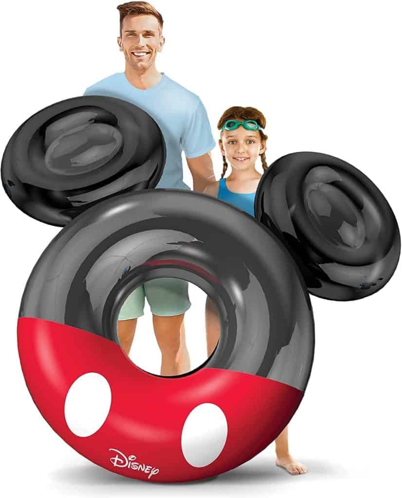 Guests of all ages share a joyful moment behind a giant Mickey Mouse-shaped pool float featuring the iconic Disney logo, reminiscent of the much-loved floats found at Disney resort pools and available in Disney parks.