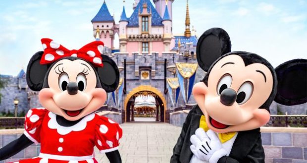 Minnie and Mickey Mouse stand in front of Disneyland's vibrant castle, greeting out-of-state guests as they join in the June 15 celebrations of Disney magic.