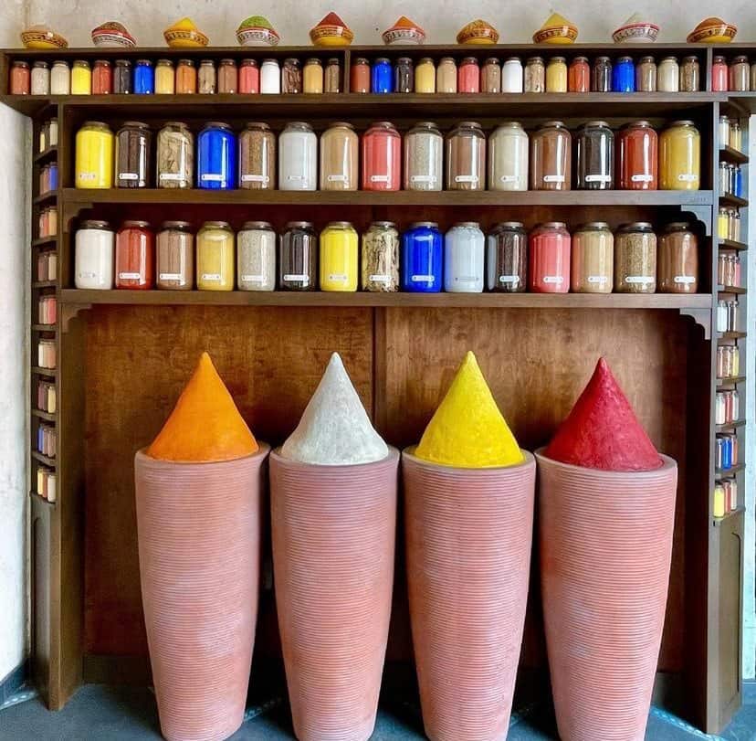 Vibrant spice jars line the shelves and four towering cones of colorful powdered spices stand proudly in front of a wooden display, perfectly capturing the lively marketplace vibe at EPCOT’s Morocco Pavilion—a place where every detail showcases Disney Imagineering magic.