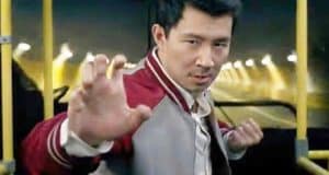 Shang-Chi performing a dynamic martial arts pose in his signature red and white jacket aboard a city bus with yellow poles, evoking the thrilling fight scene from Shang-Chi and the Legend of the Ten Rings, where unexpected Marvel character cameos delight fans and bring cinematic excitement to life.