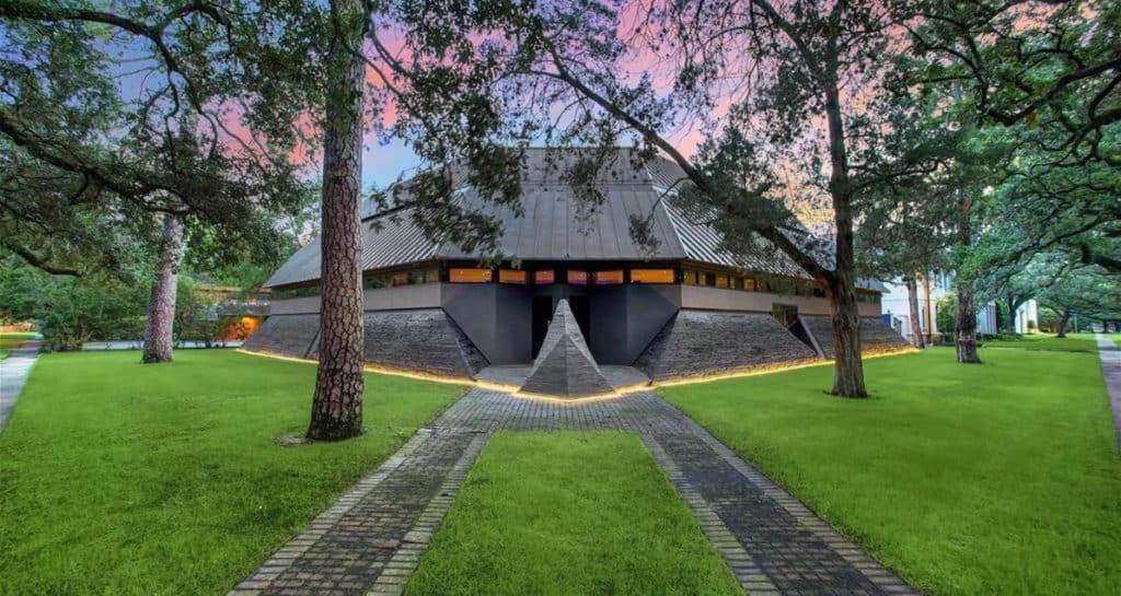 The Darth Vader House, with its futuristic dome design and expansive windows, stands out against a lush green lawn and towering trees as the sun sets—an architectural icon reminiscent of a sci-fi attraction now making headlines as it hits the market for $4.3 million.