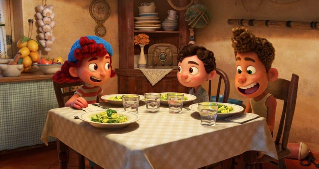 Three animated kids gather around a table in a charming, Pixar-inspired kitchen, grinning with anticipation as they prepare to enjoy pasta—capturing the heartwarming spirit and sense of friendship seen in "Luca," and evoking the inviting atmosphere guests experience at Pixar-themed eateries in Disney parks.