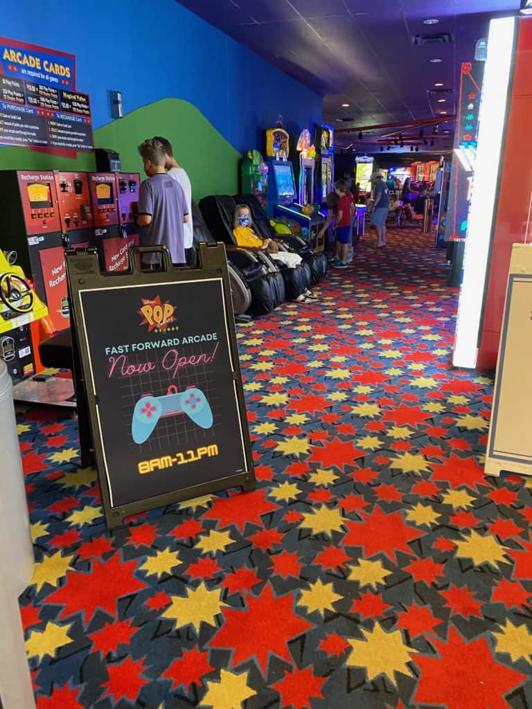 Fast Forward Arcade buzzes with energy as guests enjoy vibrant games beneath a bold sign announcing "Now Open! 8AM-11PM." Inspired by the whimsical excitement of Walt Disney World, the arcade delivers a lively, immersive playground atmosphere where every visit overflows with fun and adventure.