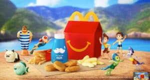 Happy Meal featuring milk, fries, chicken nuggets, and Disney Pixar Luca toys set against a vibrant beach scene reminiscent of an immersive themed attraction.