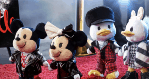 Mickey, Minnie, Donald, and Daisy nuiMOs plush toys, dressed in trendy Cruella-inspired outfits, strike a pose on the red carpet for an exclusive Disney Parks fashion event—bringing park-goers all the fun and stylish energy of their favorite characters in collectible form.