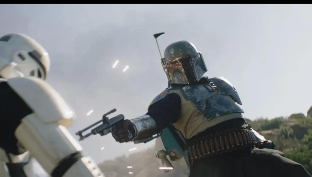 Boba Fett, in an action-packed moment from The Book of Boba Fett, fires his blaster at a stormtrooper amidst outdoor excitement, sparks lighting up the scene—capturing the cinematic thrills fans experience at Star Wars: Galaxy’s Edge.