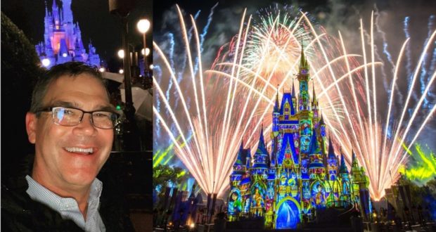 A jubilant guest enjoys a magical night at Disney World, with Cinderella Castle illuminated and spectacular fireworks lighting up the sky in celebration of the Return of Fireworks.