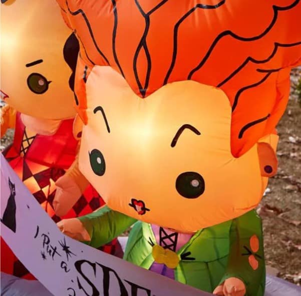 Hocus Pocus witches in vibrant costumes and bright orange hair greet guests with a playful sign in this eye-catching outdoor inflatable, bringing the magic of the beloved film to your Halloween park décor.