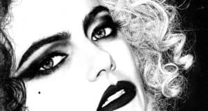 Cruella, with bold makeup, wild curls, dramatic dark eyeshadow, striking black lips, and her signature beauty mark on display—bringing Emma Stone’s electrifying villain look to life just like you’ve seen in Disney’s Parks and during special Cruella-themed events.