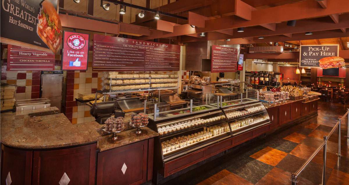 Step inside Earl of Sandwich at Disney Springs, where glass display cases showcase the latest sandwiches, menu boards hang above for easy ordering, and warm lighting highlights the inviting tiled interior—creating a welcoming spot for Disney fans eager to try new flavors in one of Disney Springs’ classic eateries.