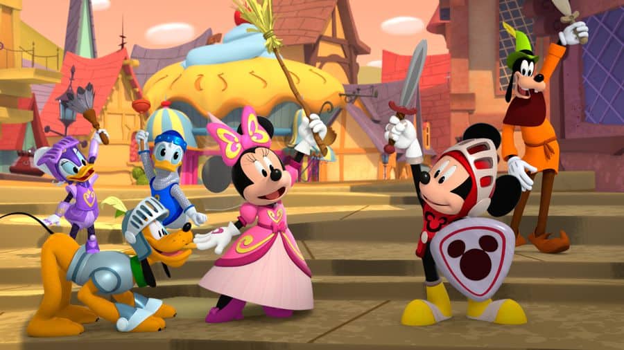 Mickey Mouse and his friends appear as brave knights and elegant royalty, brandishing swords and beaming with excitement in a vibrant town square, recreating the magic of Funhouse right in the heart of Disney World—capturing all the energy of a cinematic theme park adventure.