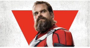 Red Guardian poses in his striking red superhero suit, set against a bold red triangle and crisp white backdrop, ready to greet fans just like at a Marvel theme park experience.
