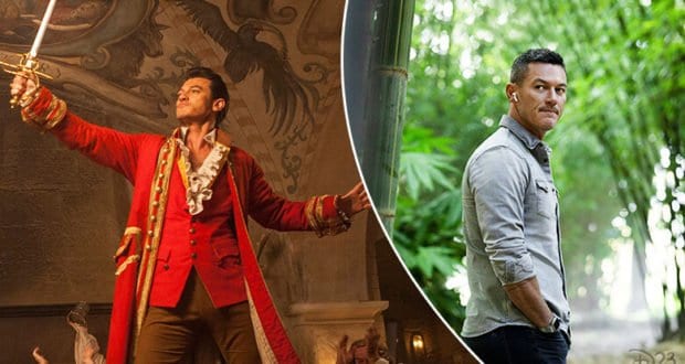 Luke Evans dressed as his swashbuckling character from Disney+’s Pinocchio, complete with a red costume and sword, alongside a casual look where he enjoys the greenery outside the set.