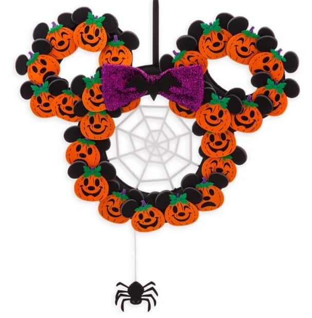 Celebrate the Halloween season at Disney Parks with a Mickey-shaped wreath crafted from festive pumpkin faces, topped with a whimsical purple bow, sparkling spider web, and dangling spider. Add this exclusive shopDisney decoration to your collection for an extra dash of spooky Disney magic at home.