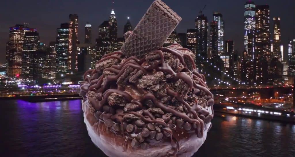 Chocolate ice cream with crunchy wafers and colorful toppings, styled like classic park treats, served in front of a vibrant cityscape sparkling with lights at night, capturing the excitement of an evening at a theme park.