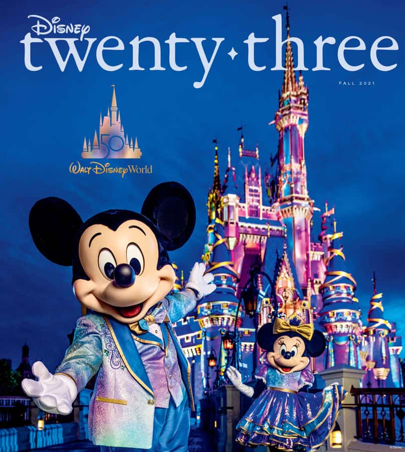 Mickey and Minnie Mouse dressed in sparkling anniversary outfits pose together in front of Cinderella Castle at Walt Disney World, celebrating the 50th Anniversary—an unforgettable scene highlighted in D23 Magazine for Disney fans.