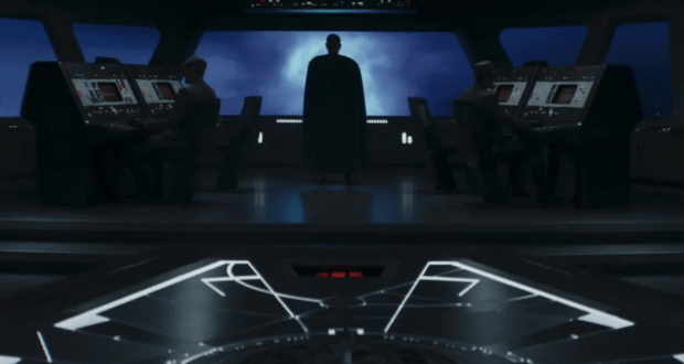 Moff Gideon, cloaked in a dramatic cape, stands silhouetted on the starship bridge surrounded by his crew at control panels, evoking an epic scene straight from Star Wars: The Mandalorian experience.