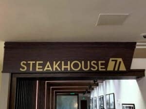 Steakhouse 71’s illuminated sign welcomes guests at Disney’s Contemporary Resort, framed by sleek wood details and a stylish hallway that hints at the resort’s signature blend of classic Disney nostalgia and modern dining.