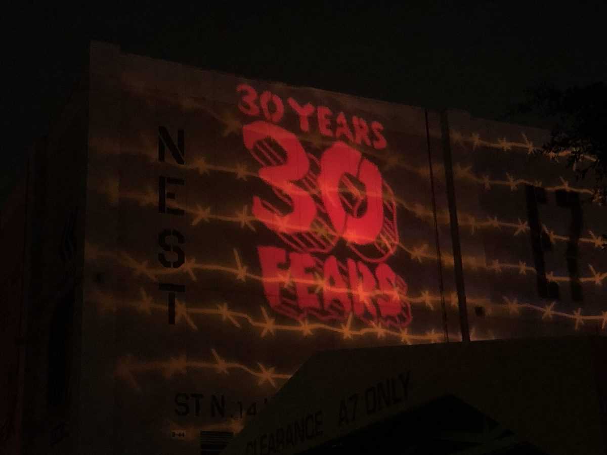 The iconic "30 YEARS 30 FEARS" Halloween Horror Nights logo glows in bold red across the façade of Universal Studios, with barbed wire graphics adding to the event's signature eerie vibe.