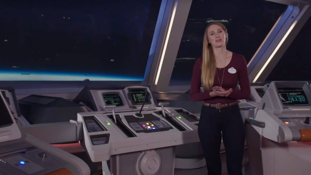 A Star Wars Galactic Starcruiser crew member stands on the immersive ship’s bridge, surrounded by interactive control panels and panoramic views of outer space, recreating the out-of-this-world atmosphere that thrilled Disney fans since its debut on March 1st, 2022.