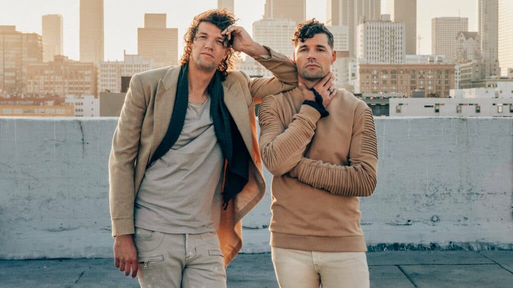 On a rooftop with Orlando’s iconic skyline in the background, two festival-goers in casual gear strike an energetic pose for the camera as they get ready to Rock the Universe at Universal Orlando Resort. Their lively spirit captures the excitement of this legendary Christian music festival high above the city.