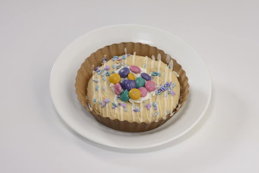 A festive cookie topped with vibrant candies and colorful sprinkles, just like the sweet treats from Main Street Confectionery at Magic Kingdom Park, displayed on a classic white plate.