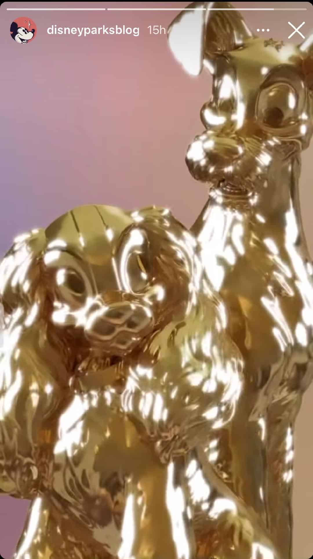 The golden Lady and the Tramp statues from Disney’s Fab 50 Character Collection shine brightly in the park, set against a dreamy pastel backdrop that captures the magic of Disney World celebrations.