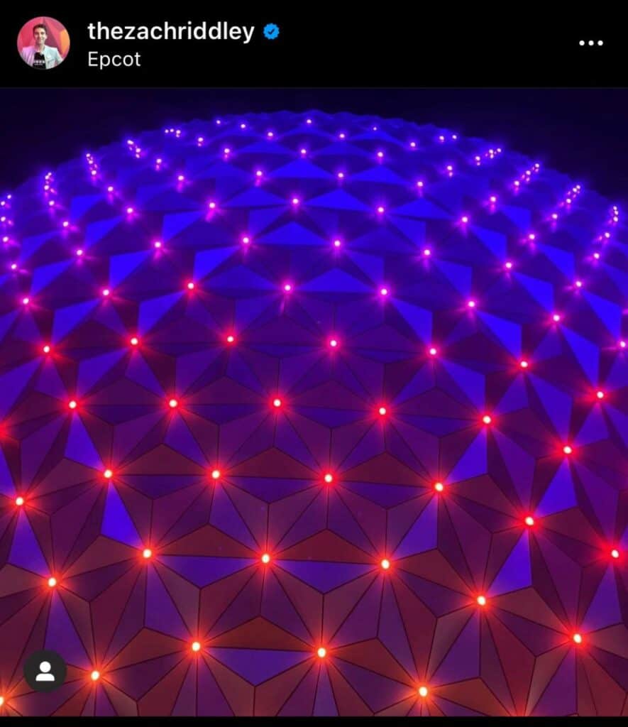 Spaceship Earth at EPCOT illuminated by vibrant red and blue lights at night, its iconic geodesic dome aglow in a stunning geometric pattern as it shines as one of the park’s Beacons of Magic.