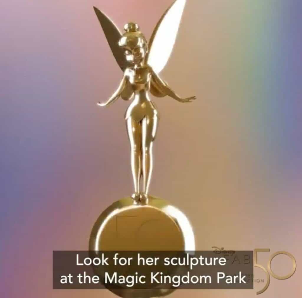 Tinker Bell golden fairy statue with delicate wings stands atop a round base. Text reads: "Look for Fab 50’s Tinkerbell sculpture, the Final Character, at Magic Kingdom Park.