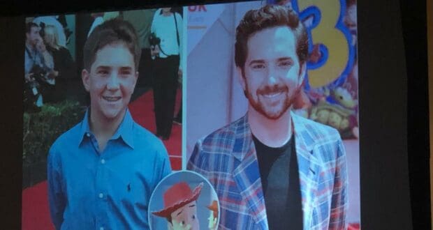 Split-screen showing a young boy and his grown-up self at a theme park, with Woody from Toy Story animated between them in the vibrant, comic-style art of John Morris.