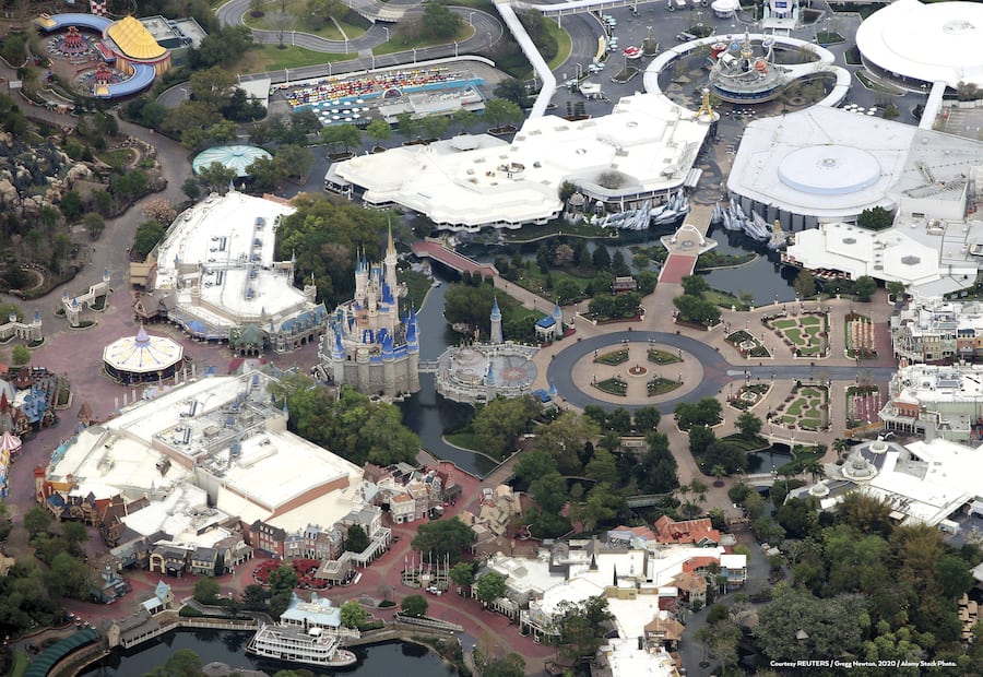 Aerial view of Walt Disney World with Cinderella Castle at the heart of the Magic Kingdom, iconic attractions, winding walkways, lush landscaping, and themed lands spreading out in celebration of 50 years of unforgettable park experiences.